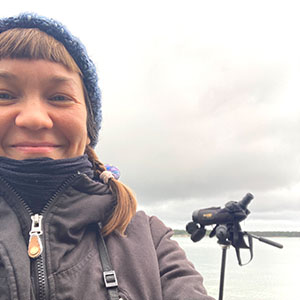 Jessica Koivistoinen with a monocular to observe birds